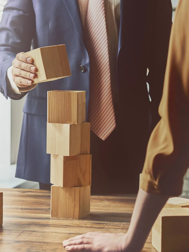 Man placing wooden block on a pile